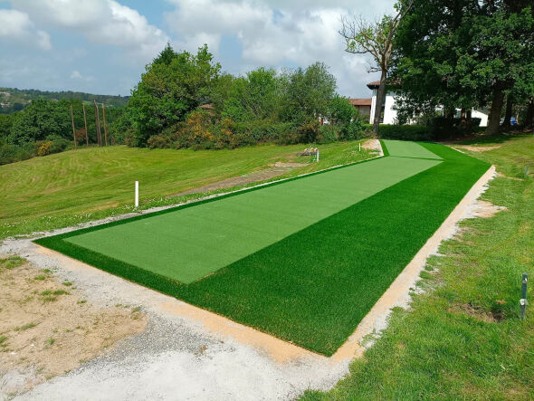 Fresno Outdoor tee line consisting of one continuous green synthetic grass strip surrounded by trees